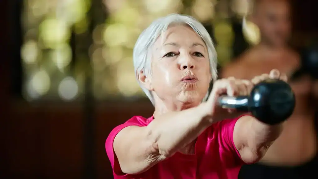 Older woman doing weight training Basingstoke  to help her strength and longevity 